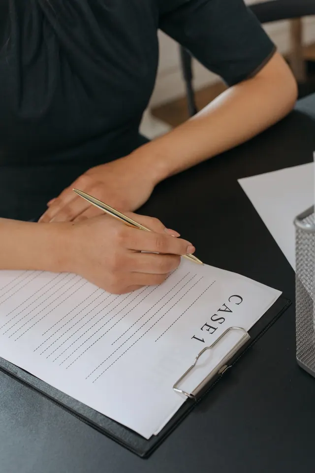Persona llenando un formulario en un escritorio