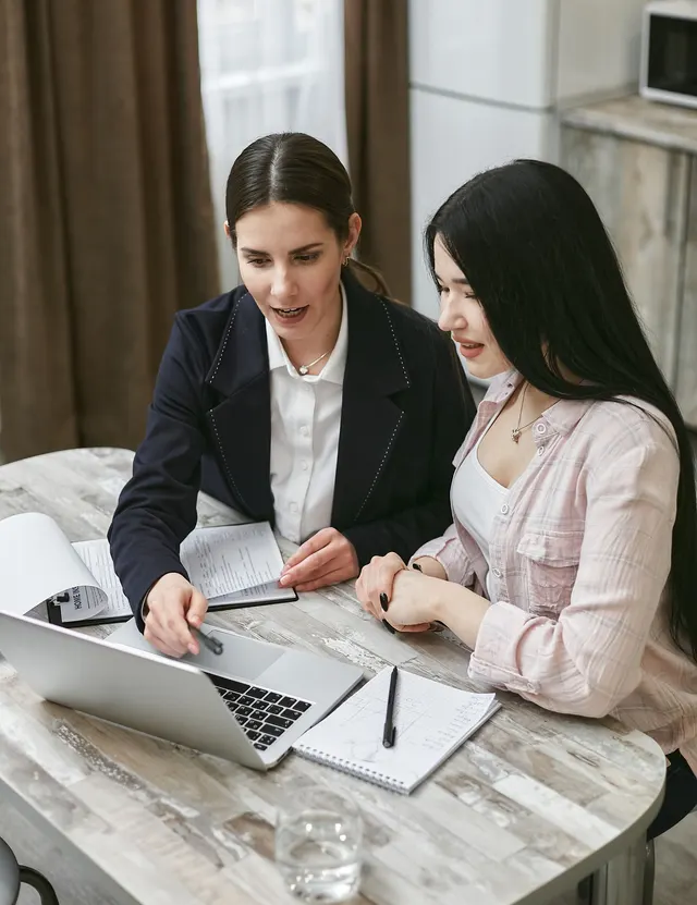 Two women talking over documents