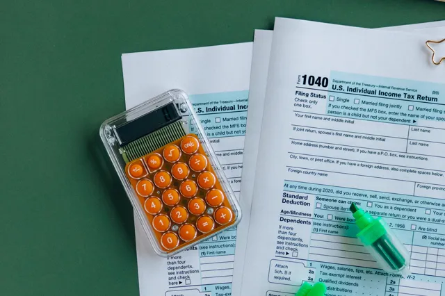 A 1040 tax form with a calculator