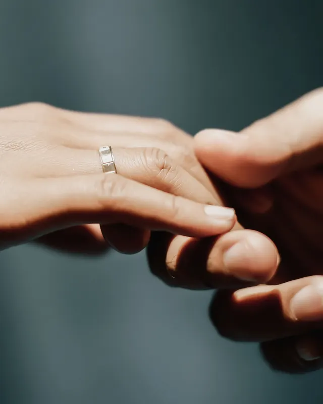 A couple's hands exchanging rings